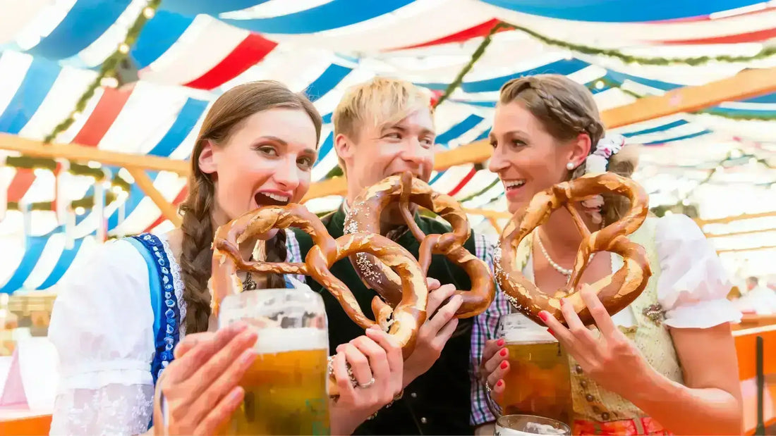 La birra Oktoberfest da conoscere assolutamente: amici con bretzel e birra all'Oktoberfest.